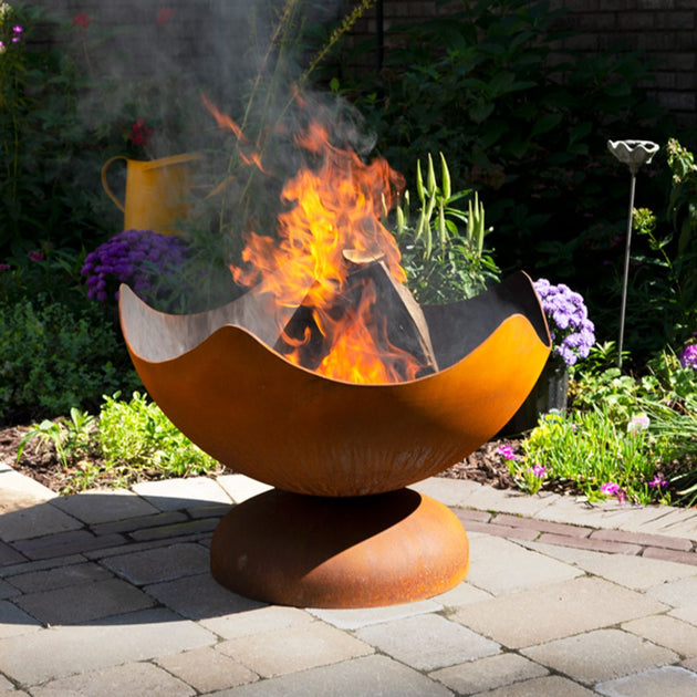 Outdoor fire pit with flames in a garden setting